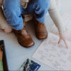 Child sitting on a white floor with educational materials